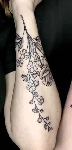 two women with tattoos on their arms, one is holding the other's arm