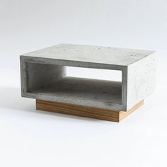 a concrete and wood coffee table with one shelf open on the side, in front of a white background