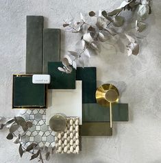 an assortment of decorative items on a white surface with silver leaves and other things in the background