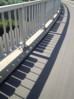 a long white fence on the side of a road