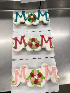 three decorated cupcakes sitting on top of each other in the shape of letters m and m