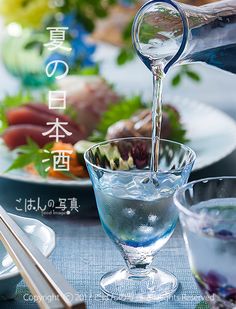 water being poured into a glass bowl with chopsticks and salad in the background