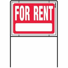 a red for rent sign sitting on top of a white wall