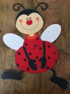 a ladybug cut out on top of a piece of wood with black and white dots