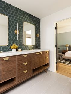 a bathroom with two mirrors, a sink and a large mirror on the wall above it