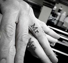 two people with matching tattoos on their fingers, one has the word mr and mrs