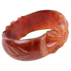 This stunning red tea marble Bakelite carved bracelet bangle features a chunky domed shape with deep floral carving. Its bold and beautiful design displays two large sculpted flowers with leaves in between and a thick-walled pattern. The amber-marbled color of red tea with cloudy swirls and transparency will bring an exotic and luxurious touch to finish your next outfit. Measurements: Inside across is 2.57 in diameter (6.5 cm) - outside across is 3.32 in diameter (8.4 cm) - width is 1.13 in (2.8 Wooden Bangle, Red Tea, Bakelite Jewelry, Stone Bangle, Marble Colors, Next Clothes, Jewelry Inspo, Bangle Bracelets, Beautiful Design