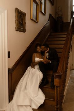 a bride and groom are sitting on the stairs