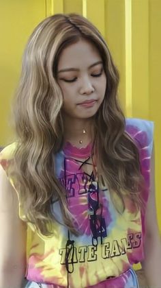 a girl with long hair wearing a tie dye shirt