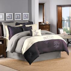 a bed with purple and white comforters in a room