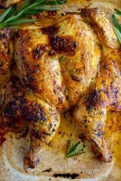 roasted chicken with rosemary garnish on a cutting board