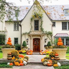 a house with pumpkins and gourds in front of it on instagram