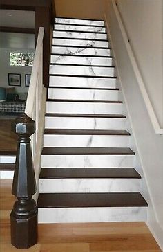 the stairs are painted white and brown with black stripes on them, along with an iron handrail