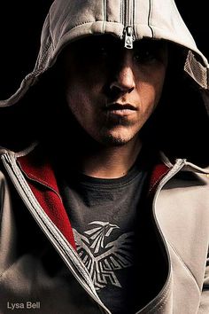 a man wearing a jacket and hoodie with a bird on it's chest