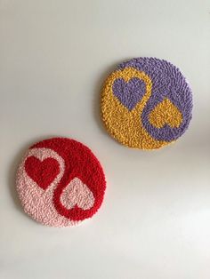 two circular coasters with the letter d and an image of a heart on them