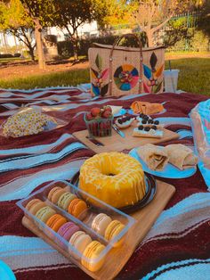 an assortment of pastries and desserts on a picnic blanket