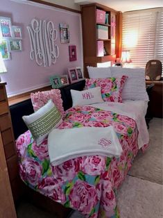 a bedroom decorated in pink and green with pictures on the wall, bedding and pillows