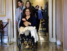 a woman in a wheelchair is surrounded by other people