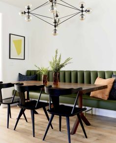 a dining room table with four chairs and a bench in front of the couches