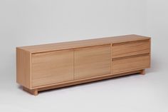 the sideboard is made out of wood and has two doors on one side, and three drawers on the other