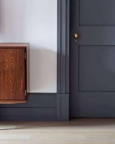 an empty room with a wooden cabinet next to the door