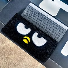 a computer keyboard sitting on top of a black rug next to a mouse and keyboard