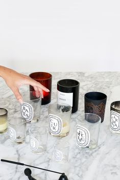 a table topped with glasses filled with different types of liquid and candles next to each other