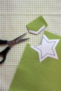 scissors are laying on top of some green material with white stars cut out of it