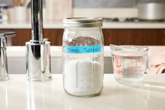 a kitchen counter with a jar, measuring cup and soap dispenser on it