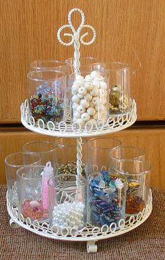 a three tiered tray with glass cups and beads