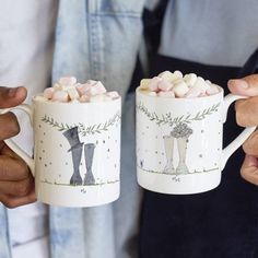 two mugs with marshmallows in them are decorated to look like boots