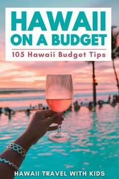 a person holding up a wine glass in front of a swimming pool with the words hawaii on