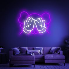 a purple couch sitting under a neon sign in a dark room with a blue wall