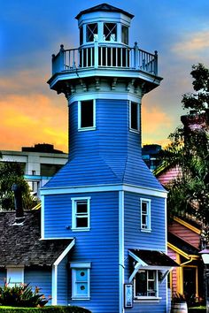 a blue house with a light tower in the background