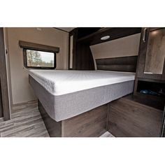 the inside of an rv with a bed and cabinets