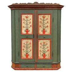 an old green cabinet with flowers painted on the front and side panels, sitting against a white background