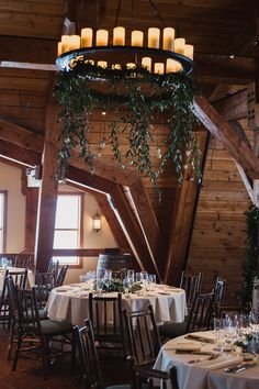 the tables are set with candles and place settings for an elegant dinner in a rustic setting