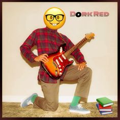 a man with glasses and a guitar poses in front of a wall that says dorkred