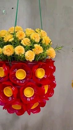 a hanging flower pot with yellow flowers in it