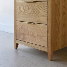 a close up of a wooden dresser with two drawers and one drawer on the side