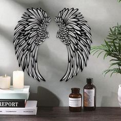 two angel wings are on the wall next to some candles