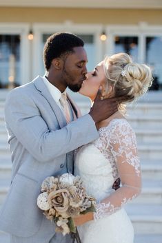 a bride and groom kissing in front of some steps