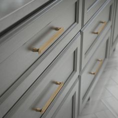 a close up of a dresser with brass handles