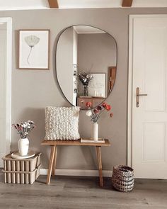 a room with a mirror, vases and flowers on the table