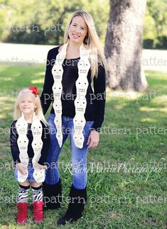 the mother and daughter are posing for a photo in front of a tree with their matching scarfs