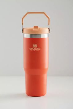 an orange insulated travel mug with the words stay strong on it and a metal lid