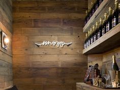 a wine shop with wooden walls and shelves filled with bottles