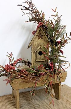 a wooden birdhouse with red berries and greenery