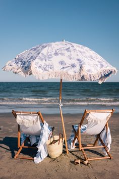 two chairs and an umbrella on the beach