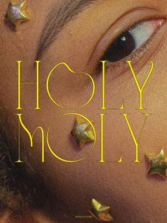 a close up of a person's face with gold stars on her nose and the words holly moly above it